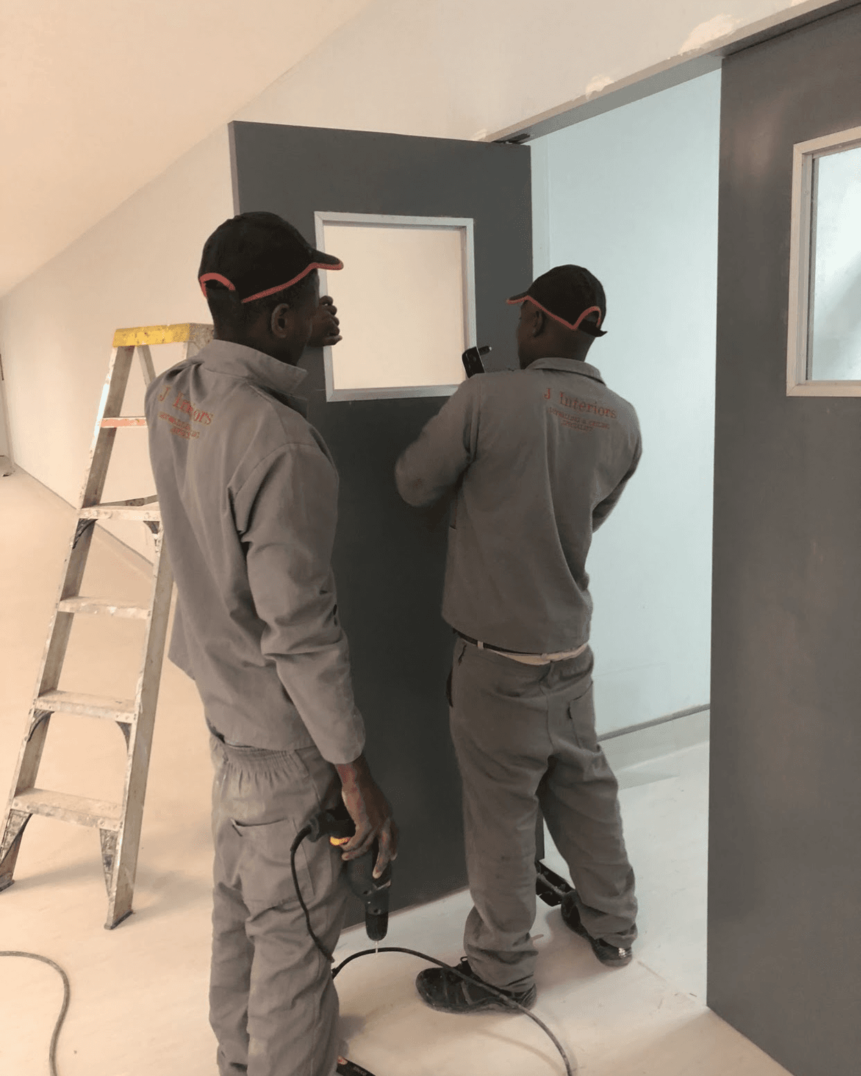 John Partition and Interiors crew installing a partition with a vision panel